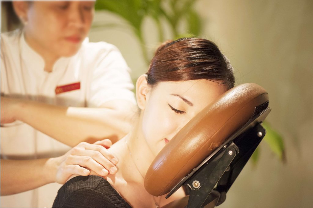 Woman receiving shoulder massage on seated chair at Kenko Wellness